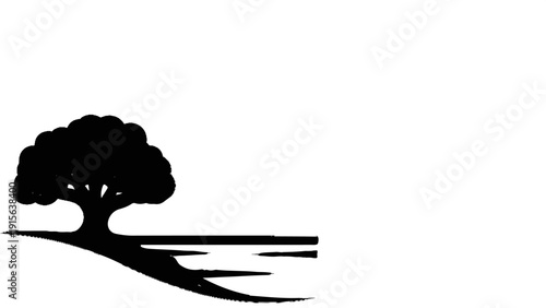 Silhouette of a large tree with a bushy canopy beside a reflective body of water