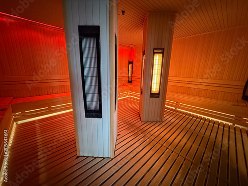 Infrared sauna cabin with central heaters and wooden floor. Heat therapy, recovery session, wellness routine, detox process, relaxation environment