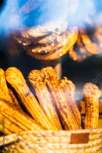 Freshly baked churros in a wicker basket on display, showcasing a delicious snack for bakery, cafe, or dessert advertising. Food photography concept.