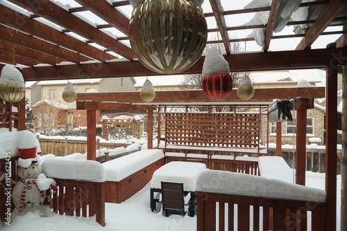Snow-covered wooden terrace with festive Christmas decorations