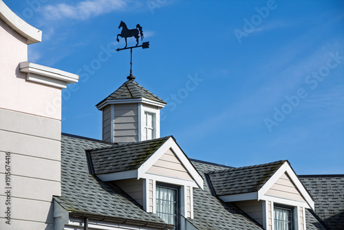 Bild auf Leinwand A gray roof with dormer windows against a bright blue sky.