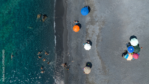 Canvastavla Top-down aerial shot of a dark-sand beach meeting clear turquoise water