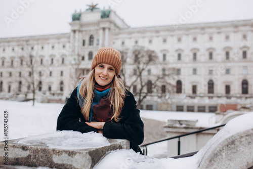 Portrait of a young woman against the backdrop of historic buildings in Vienna, Austria. 