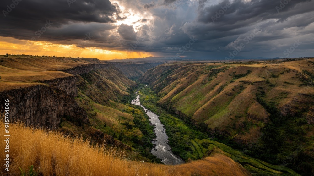 Fototapeta premium Breathtaking Aerial View of Canyon Landscape Under Dramatic Sky with Golden Sunset, Lush Green River and Rugged Hills in Nature’s Serenity