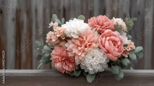 Beautiful Arrangement of Soft Peach and White Flowers with Green Eucalyptus Leaves Against a Rustic Wooden Background