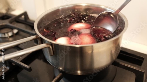 Close up of dyeing Easter eggs using natural hibiscus tea to create a deep blue marbled texture, eco-friendly DIY holiday traditions. Dyeing eggs with hibiscus creates stunning, natural shades.