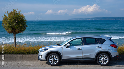 Silver SUV parked by the sea with waves and blue sky background  