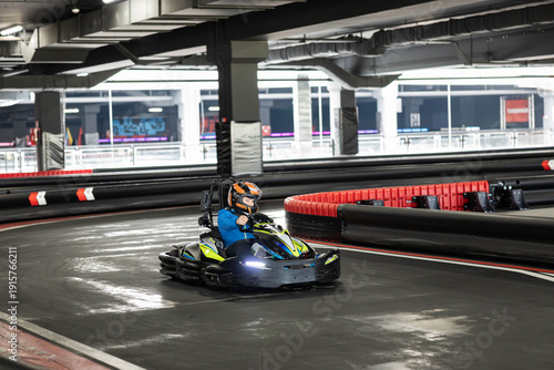 Fotografie A single go-kart speeds around a modern indoor racing track, showcasing thrilling dynamics and design
