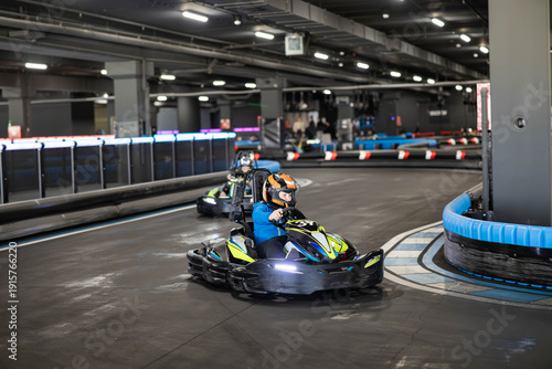 Fotografija Two go-karts racing on a sleek indoor track in an exhilarating environment filled with excitement