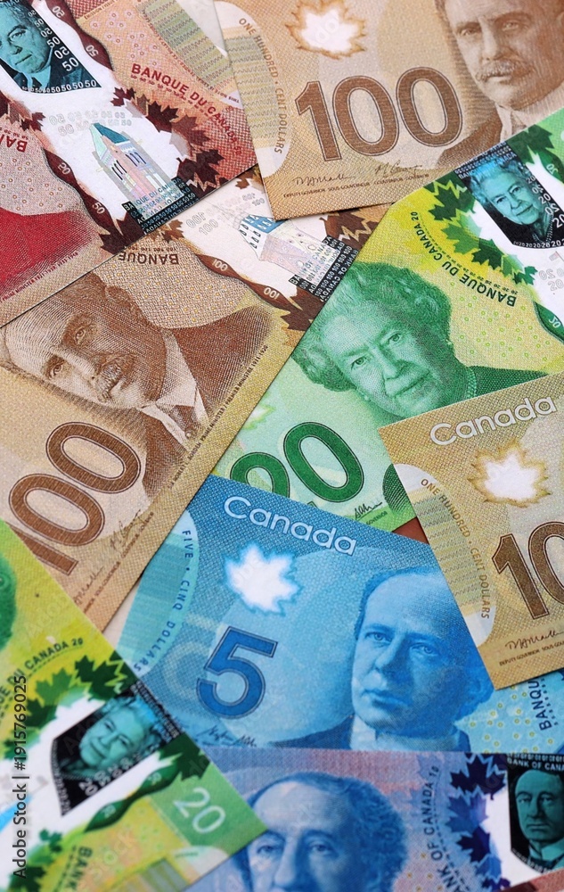 Fototapeta premium Canadian dollar money bills pile on table. Canada banknotes of CAD currency close up. Concept of business, economy and investment in Canada
