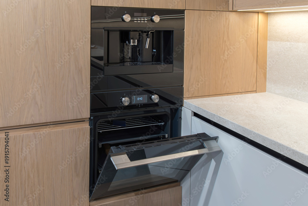 Fototapeta premium Built-in coffee machine and oven in modern minimalist kitchen