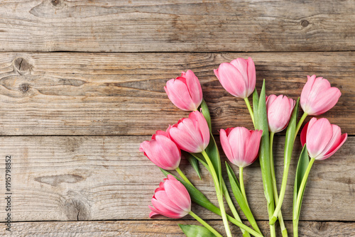 Beautiful pink tulips on wooden table, flat lay. Space for text
