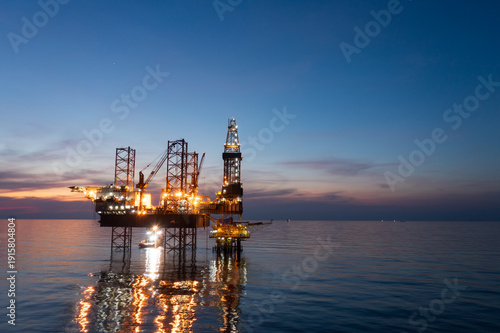 Aerial view of offshore jack up rig in a shipyard during sunset for oil and gas exploration and production.