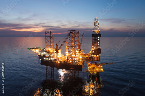 Aerial view of offshore jack up rig in a shipyard during sunset for oil and gas exploration and production.