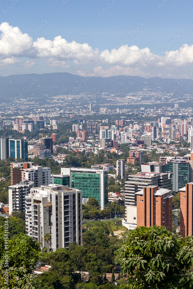 Fototapeta premium Guatemala City skyline beneath volcanic peaks