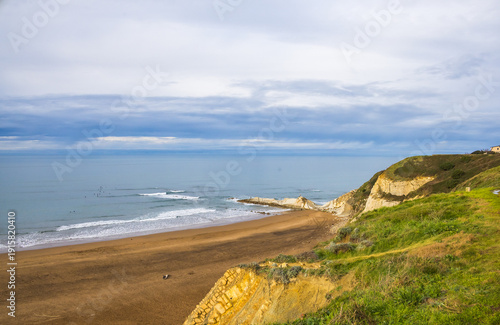 Rocky coastline and sandy beach with cliffs and ocean waves. High quality photo