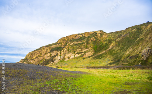 Rocky coastline and sandy beach with cliffs and ocean waves. High quality photo