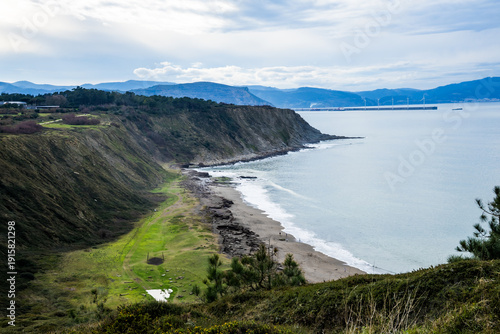 Rocky coastline and sandy beach with cliffs and ocean waves. High quality photo