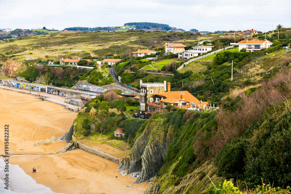 Naklejka premium Rocky coastline and sandy beach with cliffs and ocean waves. High quality photo