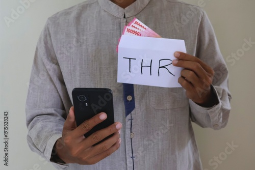 Muslim man holding a white envelope with 