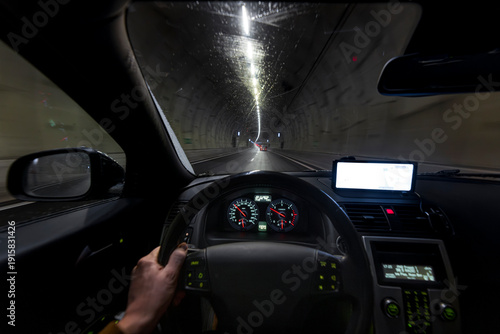 Φωτογραφία Driver hand on steering wheel with illuminated dashboard gauges and GPS navigati
