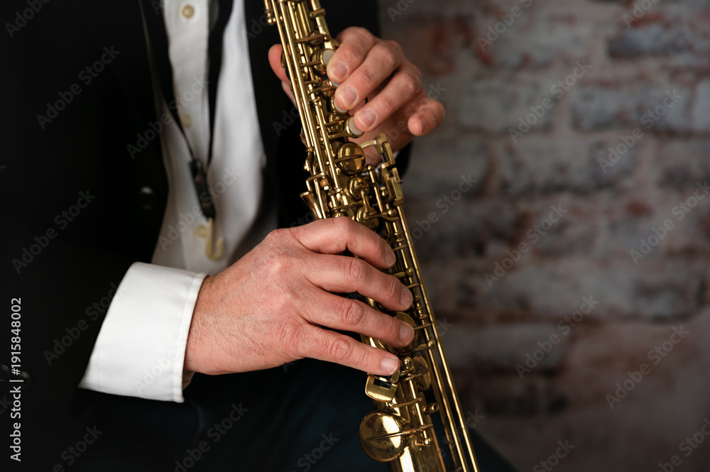 Naklejka premium man's hands playing a soprano saxophone