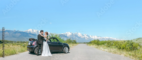 Bride and groom taking wedding photos with their beloved car (open car)