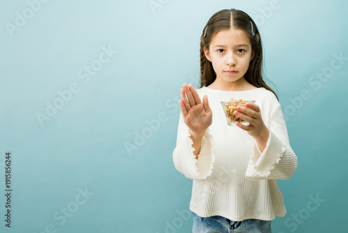 Fotografie Young girl rejecting walnuts, having an allergic reaction to nuts, suffering fro