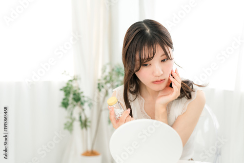 Asian woman worried about medicine and supplement bottles