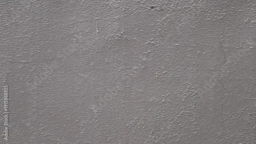 Rainwater streaming down concrete surface texture. Wet cement wall with flowing liquid pattern. Urban exterior soaked by rainfall motion backdrop. Minimal gray facade during heavy weather scene.