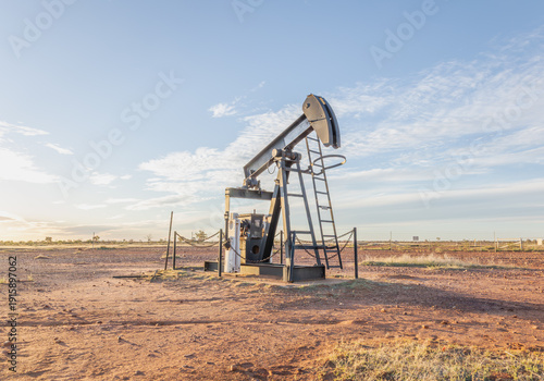 An oil pump or nodding donkey probably used to bring water rather than oil to the surface in this case, stands, no longer in use, on the flat semi-arid plains at Thargomindah in Queensland, Australia.