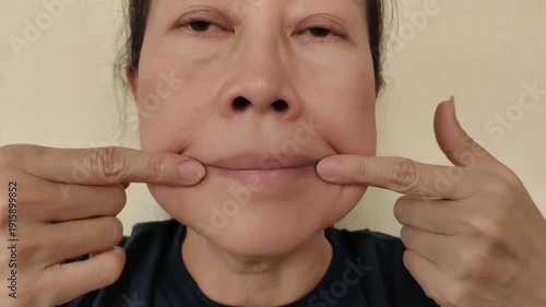 portrait the fingers holding the flabbiness adipose sagging skin, Flabby skin and line, swelling and ptosis, blemish and freckles on the face, health care and beauty concept.