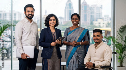 Corporate portrait of young adult Indian business professionals standing together in modern office with city view in India