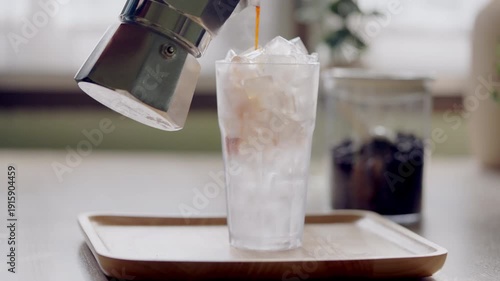 Macro close up of iced coffee pouring over ice with visible bubbles and texture. Cold caffeinated drink concept for beverage branding, cafe menu and summer refreshment.