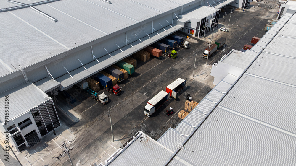 Naklejka premium Aerial view modern warehouse for trucks unloading and loading, semi truck cargo trailer at logistic park warehouse, Distribution warehouse shipping supply chain, Business transportation logistic.
