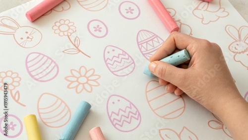 Wallpaper Mural A person colors Easter-themed designs on a cloth using pastel chalks, featuring eggs, flowers, and bunny outlines. Torontodigital.ca