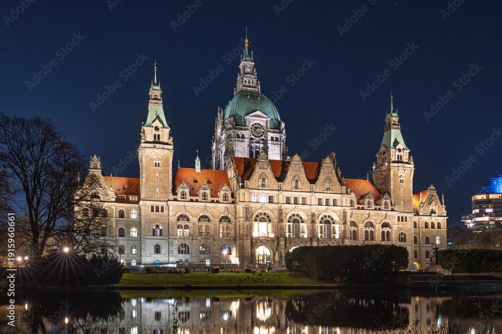 Fototapeta premium Discover the enchanting night view of Hannover, Germany, featuring the illuminated New Town Hall reflected in the serene pond. A stunning showcase of Hannover s architectural beauty.