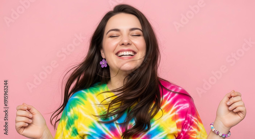 Smiling Woman in Tie-Dye Shirt with Floral Accessories on Pink Background