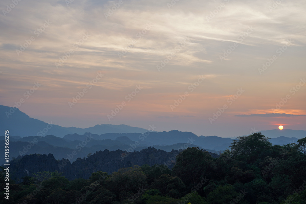 Fototapeta premium Sunset Over Layered Karst Mountains from Limestone Forest Viewpoint, Thakhek Loop, Laos