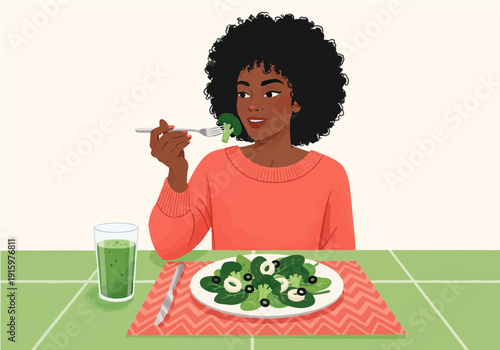 A Black woman with an afro eats a healthy green salad and drinks a smoothie at a table, promoting a nutritious lifestyle.