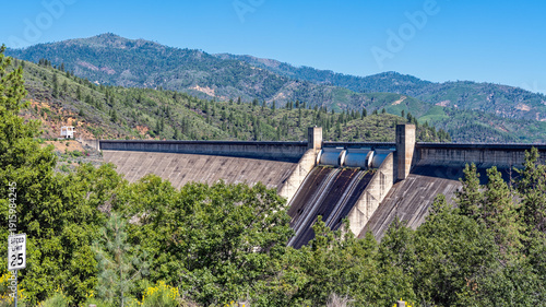 Panorama of the Shasta Dam floodgates with a speed limit sign in the foreground near Redding, California, USA