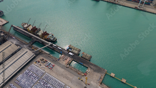 Top view of port, electric car shipping yard and intercontinental shipping industry.	