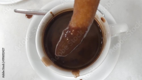 Churro dipped in hot chocolate in Madrid, capturing warmth and delight