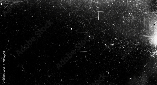 A heavy texture background mimicking old film or scratched glass with white dust particles, speckles, and linear scratches on a black background.