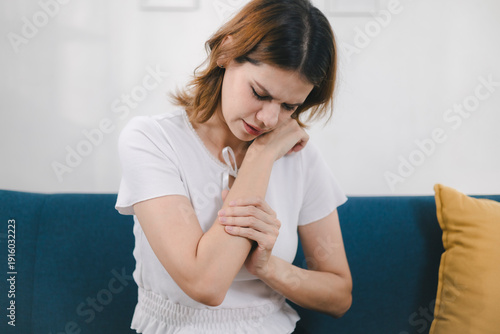 Woman touching her elbow in pain, illustrating muscle strain, joint soreness, tendon inflammation, or injury, suitable for medical, therapy, rehabilitation, and wellness content.