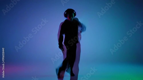 Man dancing in colorful light studio.