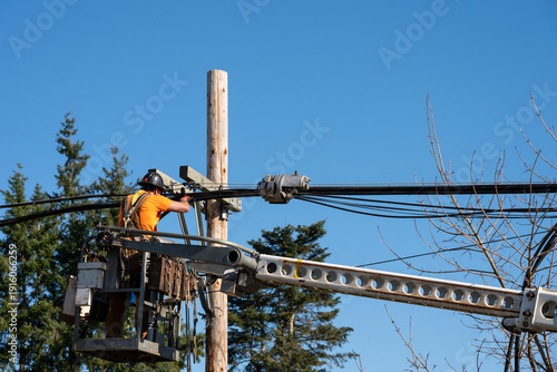 Φωτογραφία Power utility lineman in an aerial lift bucket using a Cable Lasher to upgrade u