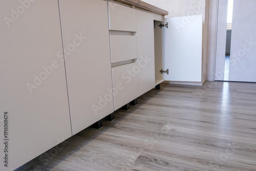 Billede på lærred Modern kitchen base cabinet with white minimalist drawers and an open cupboard d