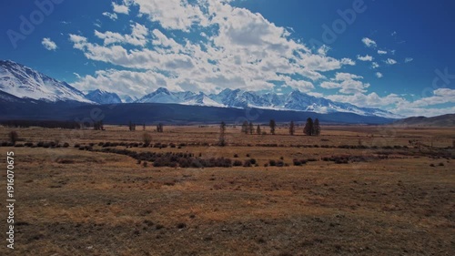 Beautiful landscape road in autumn forest with snow peaks mountains Chuysky tract, Altai Kurai steppe Russia. Aerial top view.