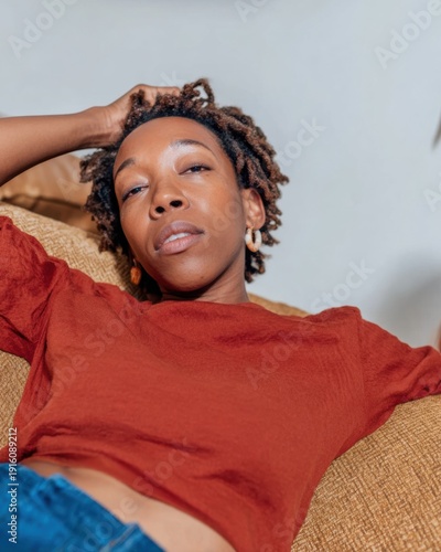 Young Woman Holding Head in Pain While Sitting on Sofa, Concept of Migraine and Menstrual Period Cramps for Medical Care App Advertising with Copy Space